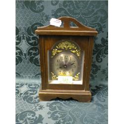 An early 20thC.. oak cased mantel timepiece, the silvered dial with  Arabic numerals, gilt spandr