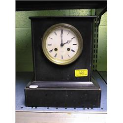 A 19thC. slate mantel clock with enamel dial, 8-day movement striking  a bell, 10" high.