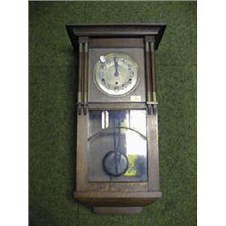 A 1920's oak wall clock with 8-day chiming movement.