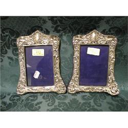 A pair of Edward VII silver photograph frames, embossed with putti,  scrolls and foliage, velvet