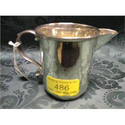 A George V silver cream jug, of plain form with scroll handle,  engraved 'Dora Moffitt, Jan 9th 1
