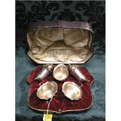 A late Victorian silver cruet set comprising 3 salts, oval with  shaped everted rims on pad feet,