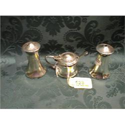 A silver cruet set comprising salt cellar, pepperette and mustard, of  plain swept shape, Sheffie