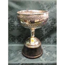 An Indian white metal racing trophy, circular, chased with bands of  flowers and foliage, with co