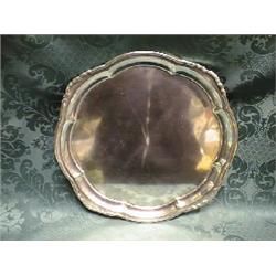 A white metal salver, having a raised shaped border, on 3 feet,      12 1/2" dia, (tests as silve