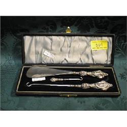 An Edward VII silver dressing set, cased, having handles cast with  shells, C scrolls and flowers