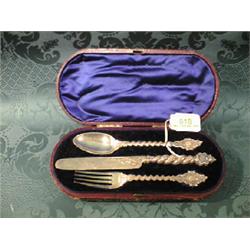 A Victorian child's silver knife, fork and spoon presentation set,  the twist, guilloche handles