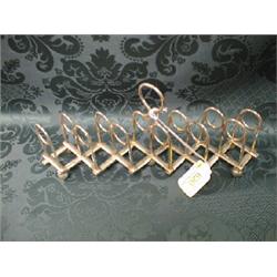 An EPNS 7-bar expanding toast rack, with twin loop divisions, on bun  feet.