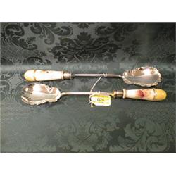 A pair of early 20thC. EPNS salad servers, the porcelain panels  decorated with flowers and folia