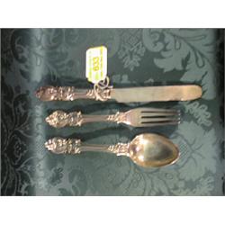 A Victorian child's silver knife, fork and spoon set, the handles  cast with scrolls and foliage,