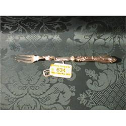 An Edward VII silver handled pickle fork, cast with foliage and shell, Sheffield 1904.