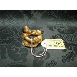 A Japanese ivory nesuke, study of 2 brothers playing, the elder on  his knees, the other rising.