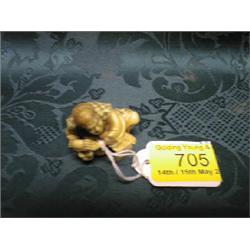 A Japanese ivory netsuke study of a noh play mask-maker seated by his  working clogg.