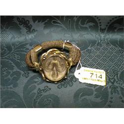 A yellow metal and hair memorial bracelet with hair insert.