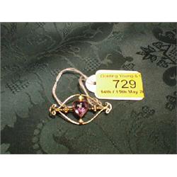 A Victorian bow brooch with scrolled ends, applied quatrefoil motifs  and central heart shaped am