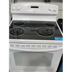 GE white stove with black glass top range