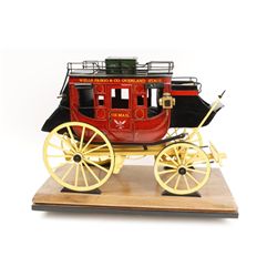 Handmade and carved from wood miniature  stagecoach with painted decoration displaying  “Wells Fargo