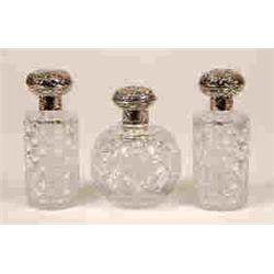 A Set of Three Cut Glass Scent Bottles, with silver mounts, decorated  scrolls and figures, Londo...