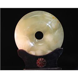 ROUND JADE STATUE WITH ANTIQUE WOOD BASE.