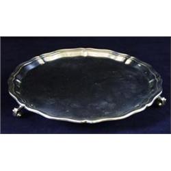 A GEORGE V SHAPED CHIPPENDALE STYLE WAITER: with raised pie-crust  edge, raised three snail feet,...