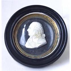 AN EARLY 19TH CENTURY MINIATURE RELIEF MALE BUST: plaster set in  convex glass, signed Desprez Ru...