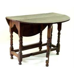 A 19TH CENTURY OAK D-END GATELEG TABLE: on baluster supports united  plain stretchers, on turned...