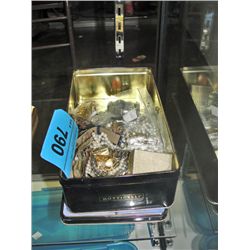 Metal tin filled with assorted costume jewelry and
