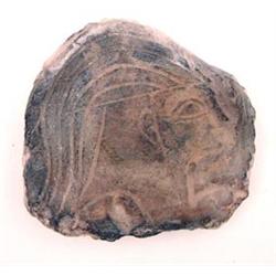 An Egyptian limestone relief fragment of a head with swept back hair, 3ins £100-150...