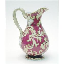 A Victorian earthenware jug moulded with grapes and painted with cream leaf scrolls against a cla...