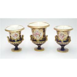 An early 19th century bone china garniture of campana vases painted with bouquets of flowers with...