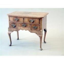 A George I walnut lowboy with canted top and fitted with an arrangement of 2 over 3 short drawers...