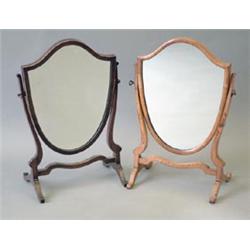 A Victorian walnut shield shaped skeleton toilet mirror, 15ins and a similar Edwardian mahogany m...