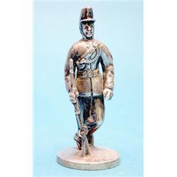 A white metal figure of a fusilier mounted on a Victorian silver plinth, 3ins. £150-200...
