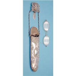 An Edwardian silver chatelaine spectacle holder with a pair of gilt wire rim spectacles £100-150...