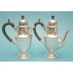 A pair of George V silver cafe au lait pots with ebonised handles (gross 25ozs) £250-300...