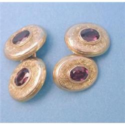 A pair of foliate engraved gold oval cufflinks set faceted oval garnets £150-250...