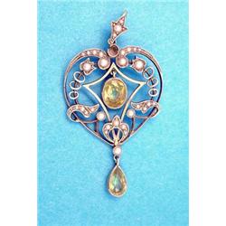 An Edwardian 15ct gold heart shaped openwork pendant set peridots and seed pearls £100-150...