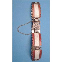 A silver flexible bracelet of 6 rectangular white and brown enamelled plaques spaced by pairs of...