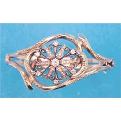 A 14k gold hinged bangle, the openwork scrolled front with a central diamond and seed pearl set 6...
