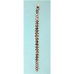 A white gold graduated line bracelet set oval sapphires flanked by rows of small diamonds, 6.75in...