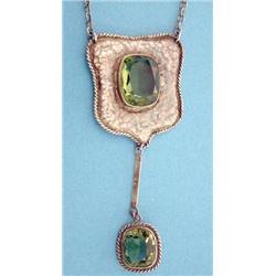 An Arts and Crafts design shield shaped hammered silver pendant necklace set with an oval faceted...