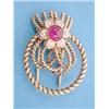 Image 1 : A Cartier, London, gold dress clip designed as rope twist loops tied with a cabachon ruby and 6 s...