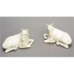 A pair of biscuit models of recumbent horses each with head turned to one side, 15.5cm (see illus...