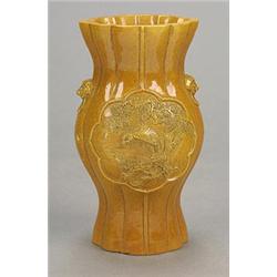 A brown-glazed vase of lobed baluster form carved with a landscape panel on one side and an eagle...