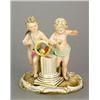 A Meissen (outside decorated) group of two putti with a parrot, modelled standing either side of...