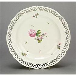 A Berlin reticulated dessert plate, painted with scattered sprays of flowers, within a shaped rim...