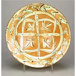 A Spanish maiolica conical bowl, the top side painted in shades of ochre, green and blue with a g...