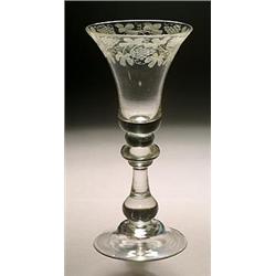 An engraved baluster wine glass, the bell bowl with a band of fruiting vine, supported on a knop...