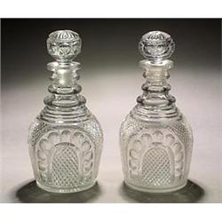 A pair of cut club-shaped decanters and stoppers, cut with arched panels of circles reserved on a...