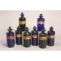 Eight similar blue chemists' bottles and stoppers, of shouldered cylindrical form, one applied wi...